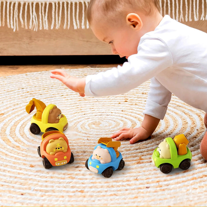 Toddler playing with four animal pull-back cars on a rug