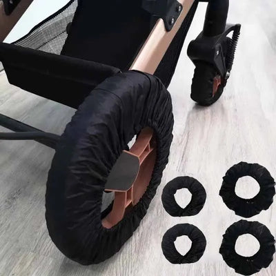 Black stroller wheel covers fitted on a stroller, with spare covers on the floor